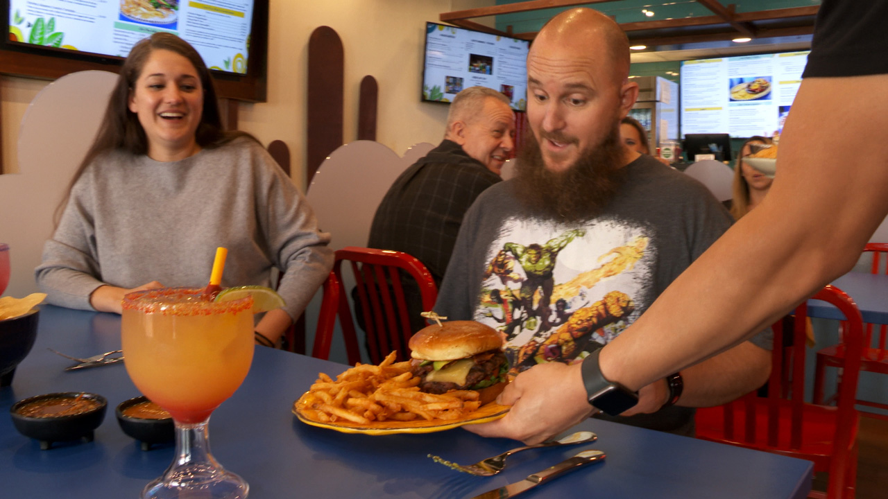 Patron being served a burger at Don Diego Mexican Cafe