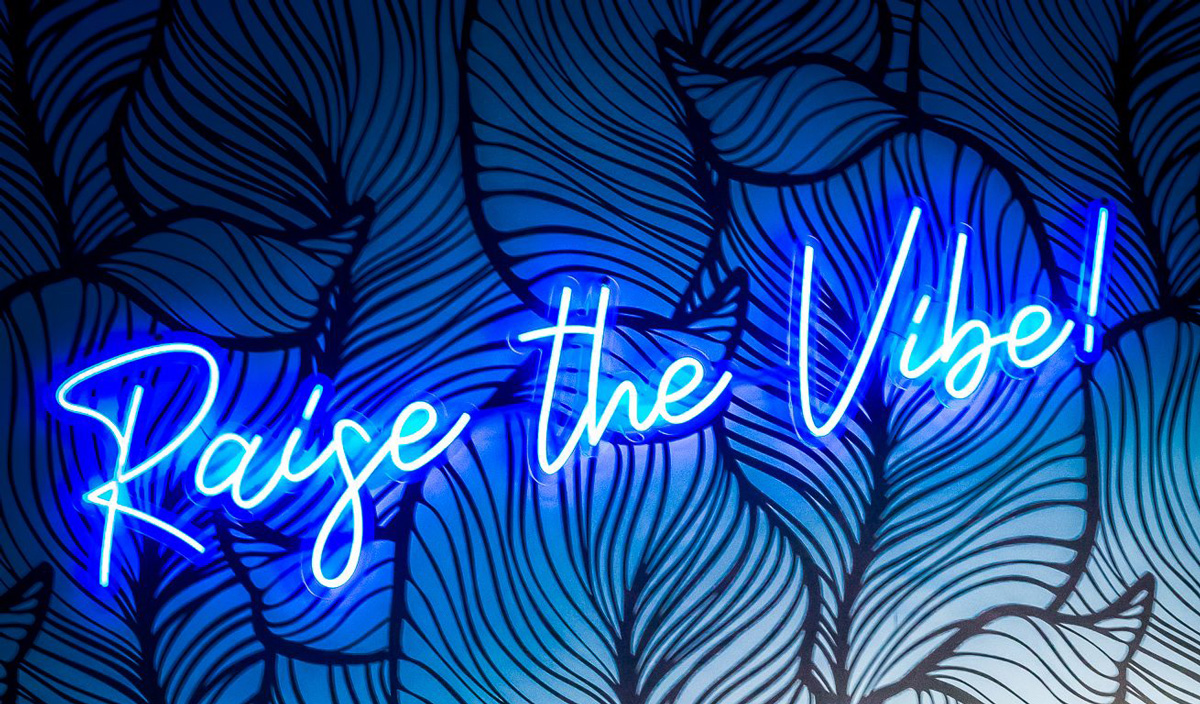 Neon sign saying Raise The Vibe at Lacuna Kava Bar in Sedona